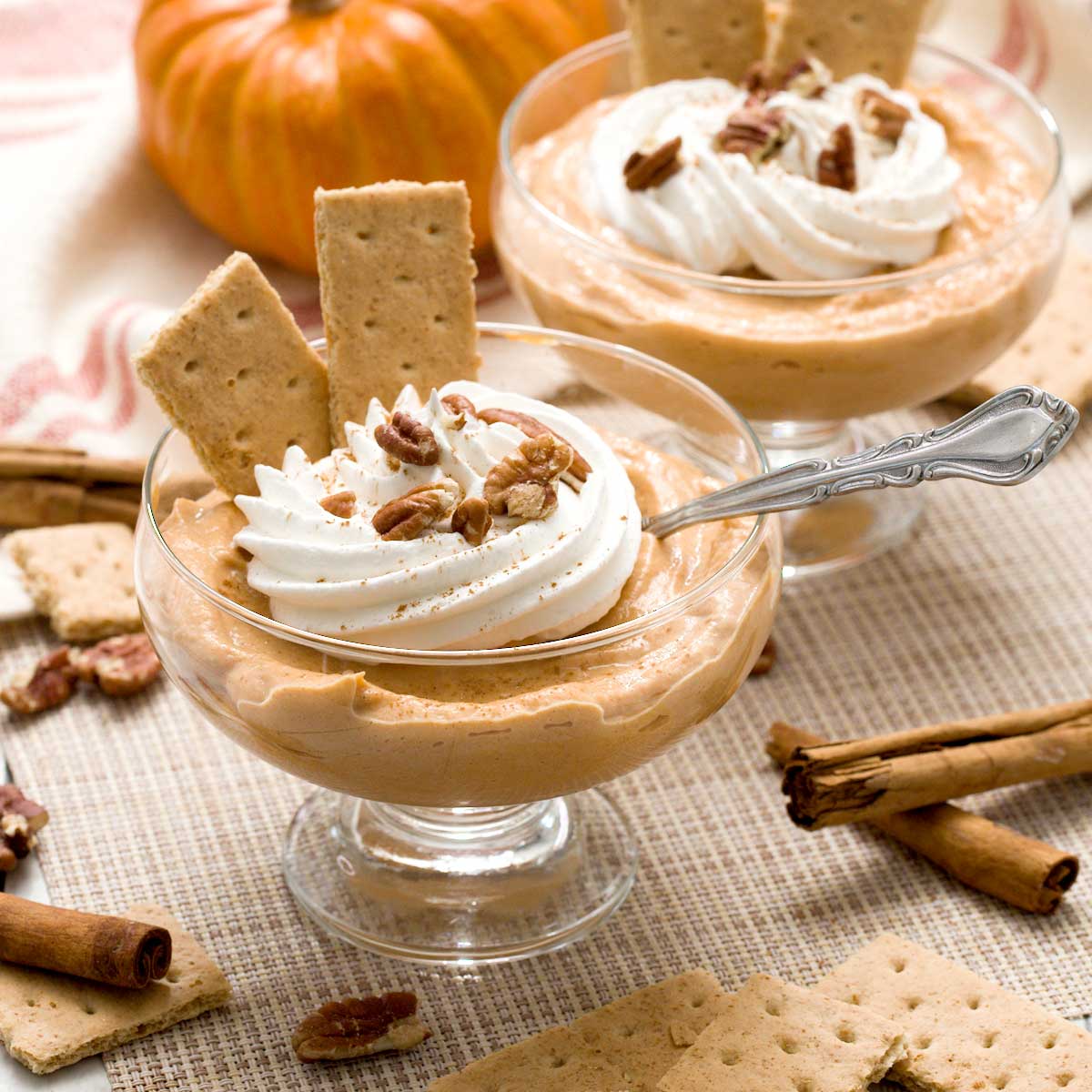 Two bowls of protein pumpkin pudding with cottage cheese and whipped cream on top.