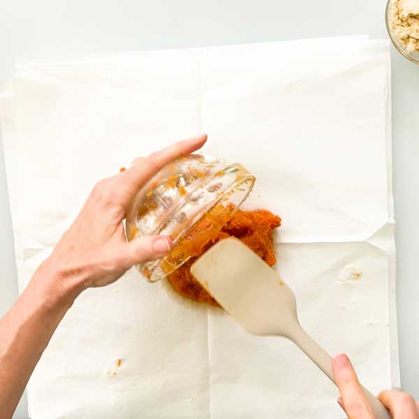 Dumping the pumpkin puree to the center of the layers of napkins.