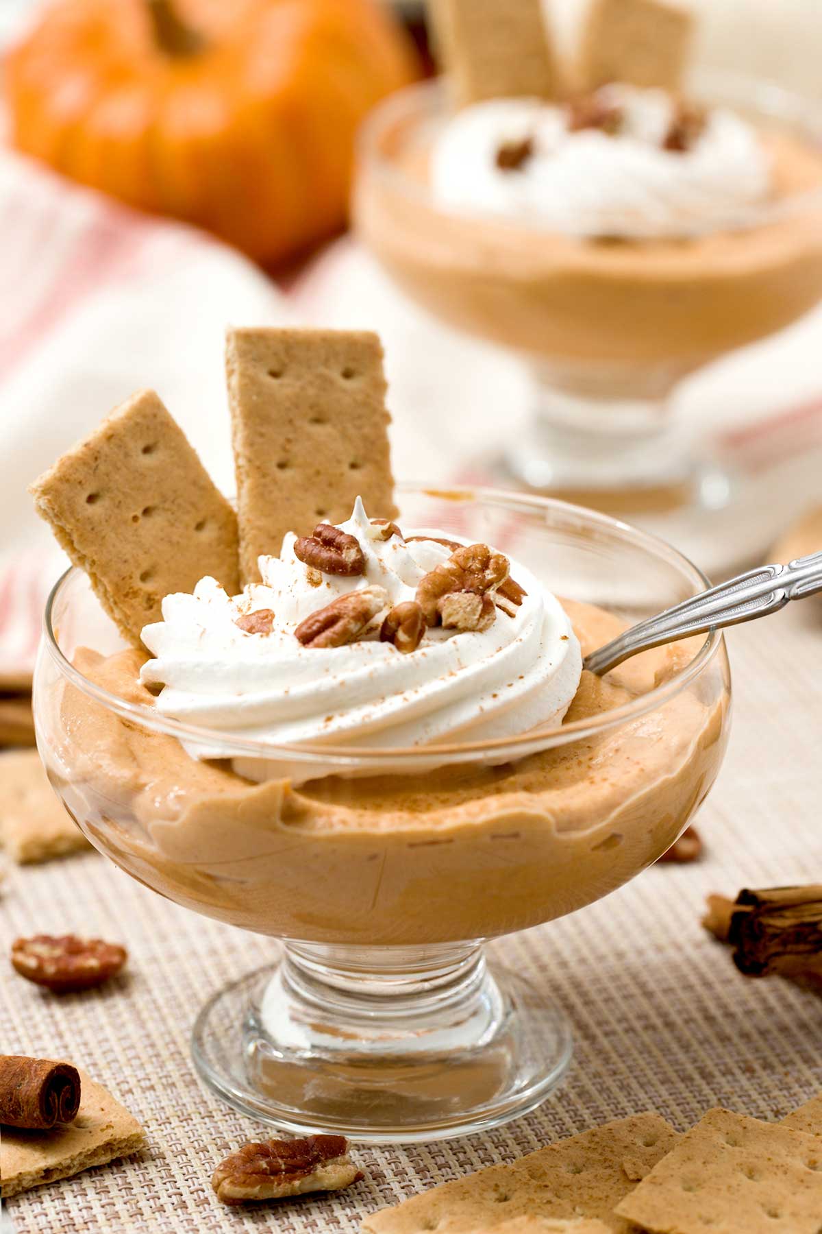 Close up of a bowl of protein pumpkin pudding with cottage cheese and whipped cream on top.