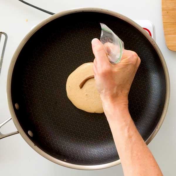 Piping the cinnamon butter swirl on the top of the pancake.