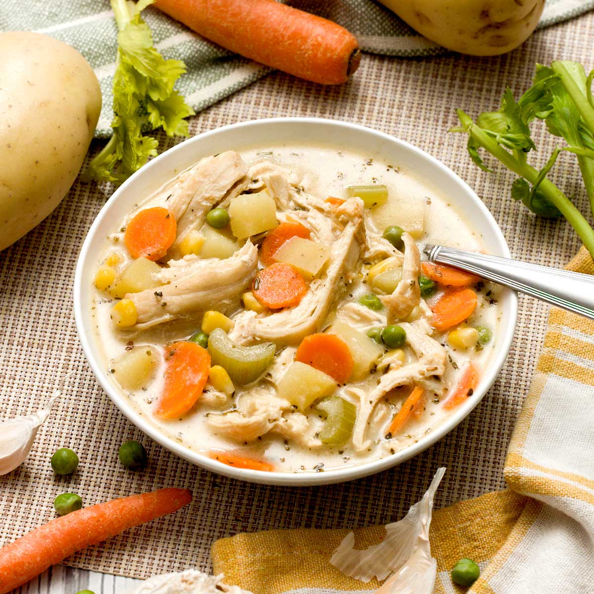 A bowl of gluten-free healthy chicken pot pie soup with potatoes, carrots, pan-seared chicken and greek yogurt.