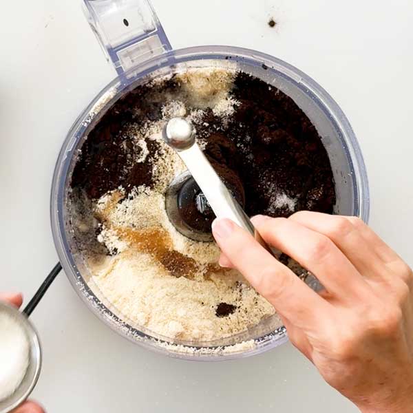 Adding all the cheesecake crust ingredients to a food processor.