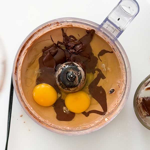 Adding the melted chocolate and eggs to the cheesecake filling.