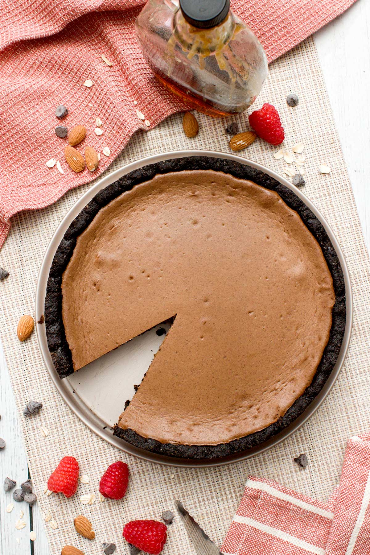 The top view of a chocolate cheesecake with cottage cheese and protein powder and a slice taken out of it.