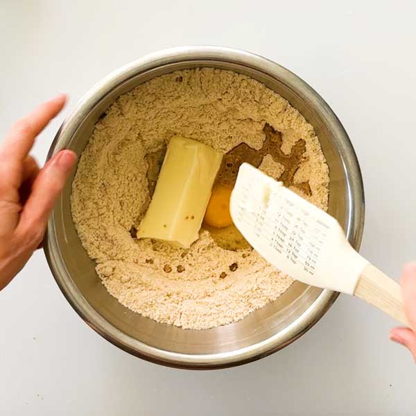 Adding all the pie crust ingredients to a bowl.