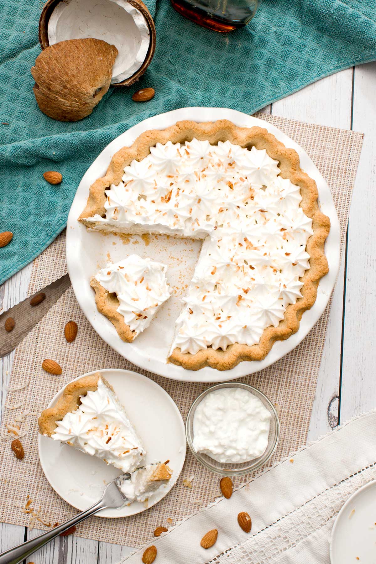 A top view of a slice of gluten-free coconut cream pie with an almond-flour pie crust and toasted coconut on top.