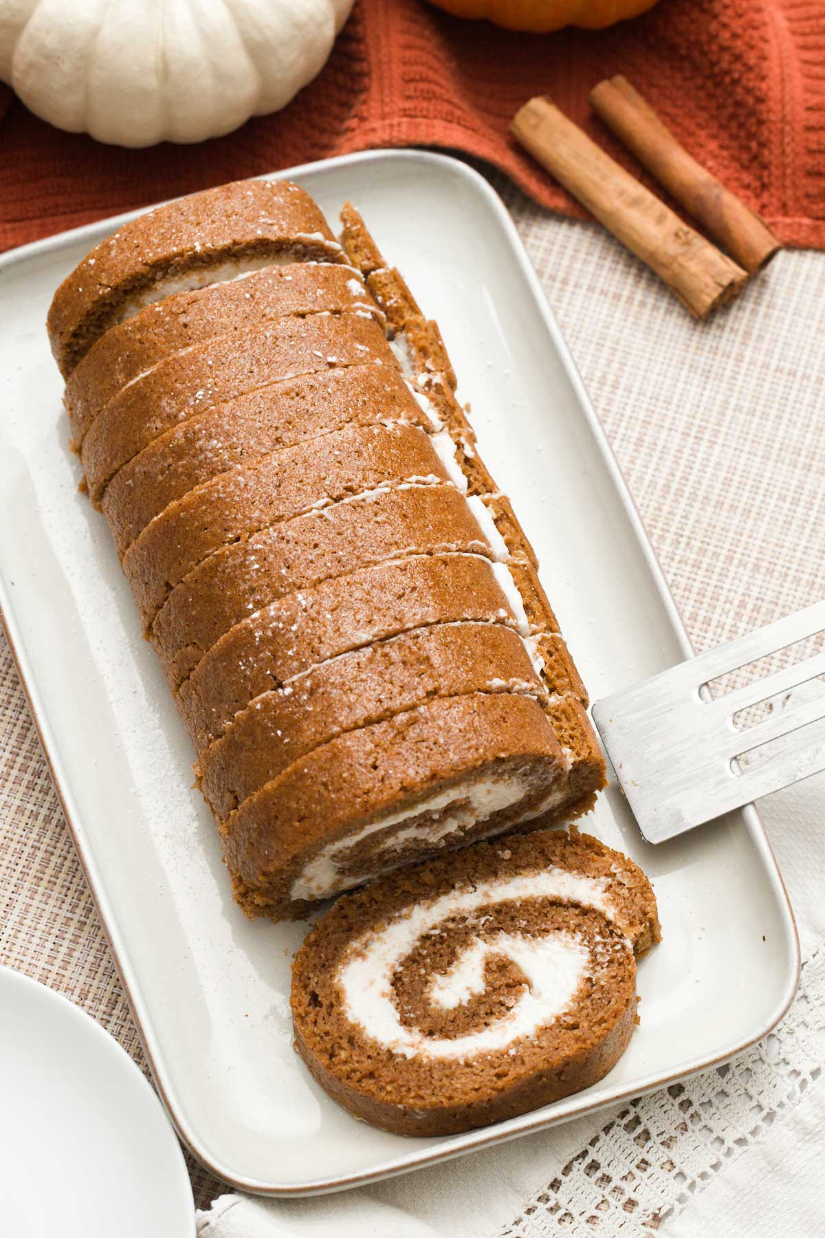 The top view of a healthy, gluten-free pumpkin roll with cottage cheese filling on a plate.