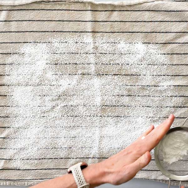 Sprinkling the dish towel with powdered sugar.