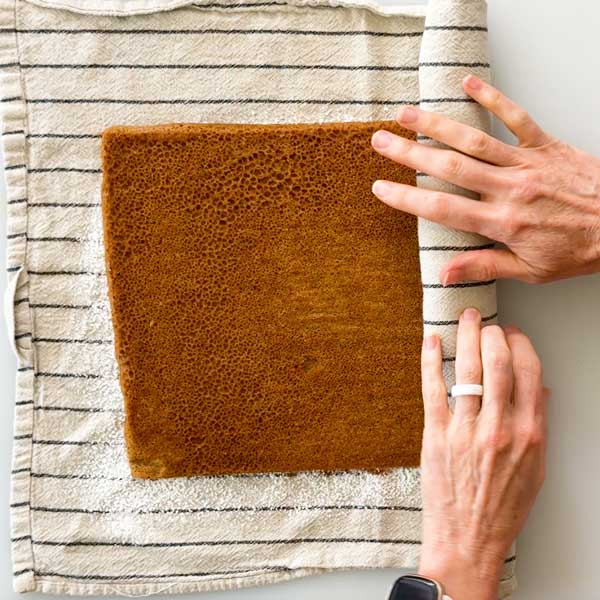 Rolling up the warm baked cake in a towel.