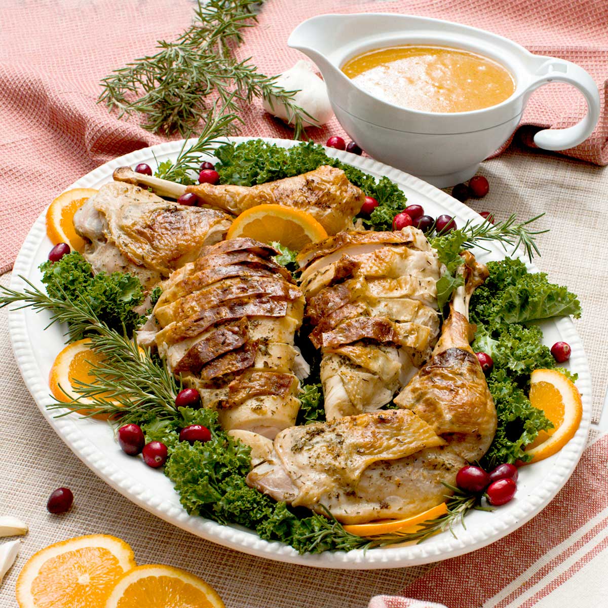 A crispy spatchcock turkey with gluten-free gravy on a serving platter.