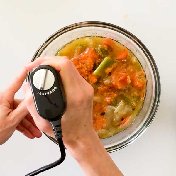 Lightly blending the vegetables in a bowl.