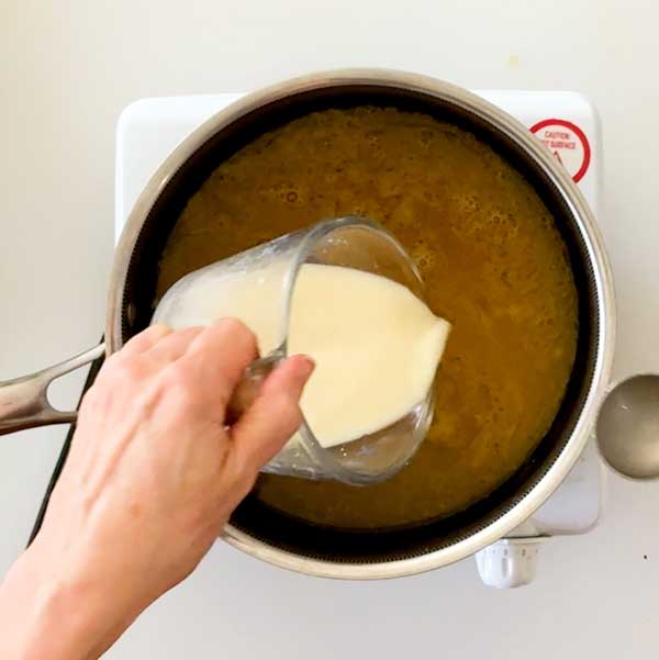 Pouring the cornstarch into the gravy to thicken it.