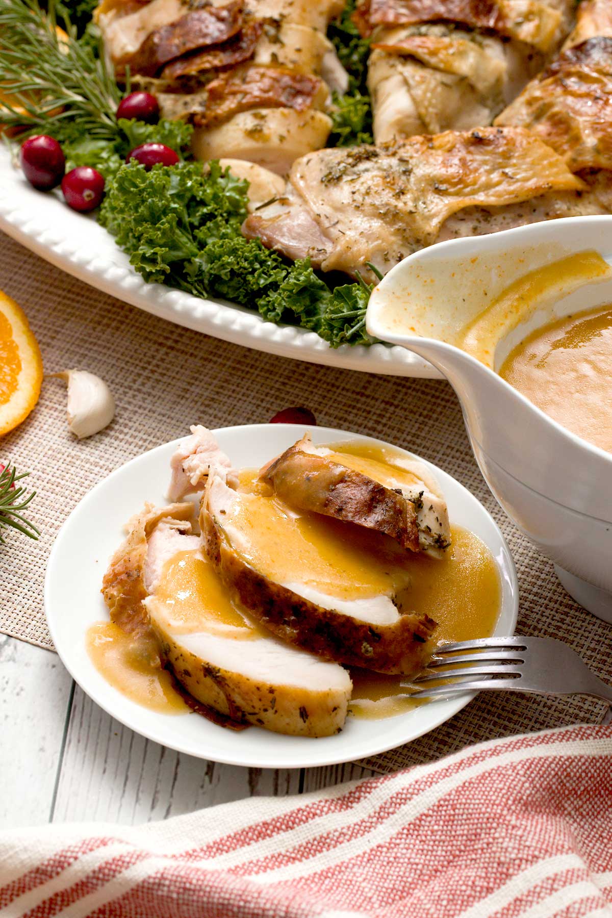 Slices of spatchcocked turkey on a plate with gluten-free vegetable gravy.