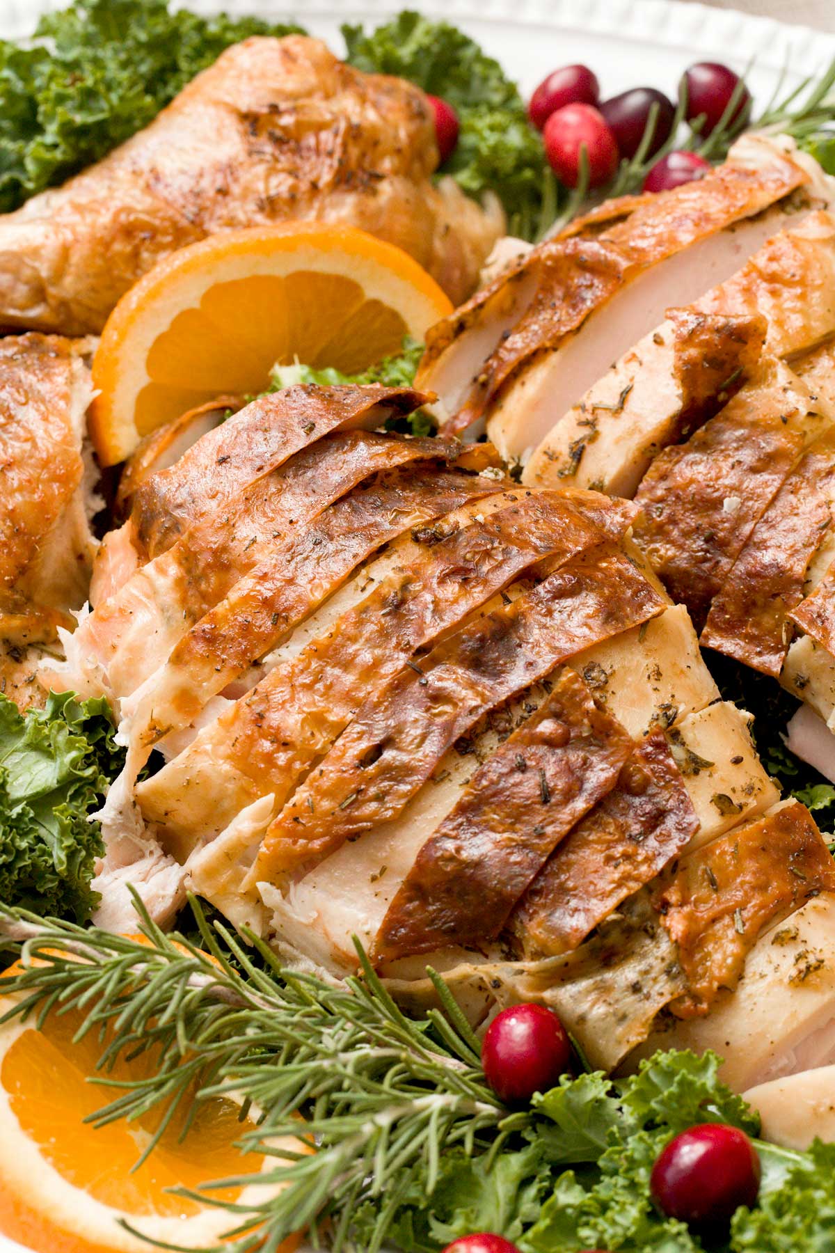 A close-up of A crispy spatchcock turkey with gluten-free gravy on a serving platter.