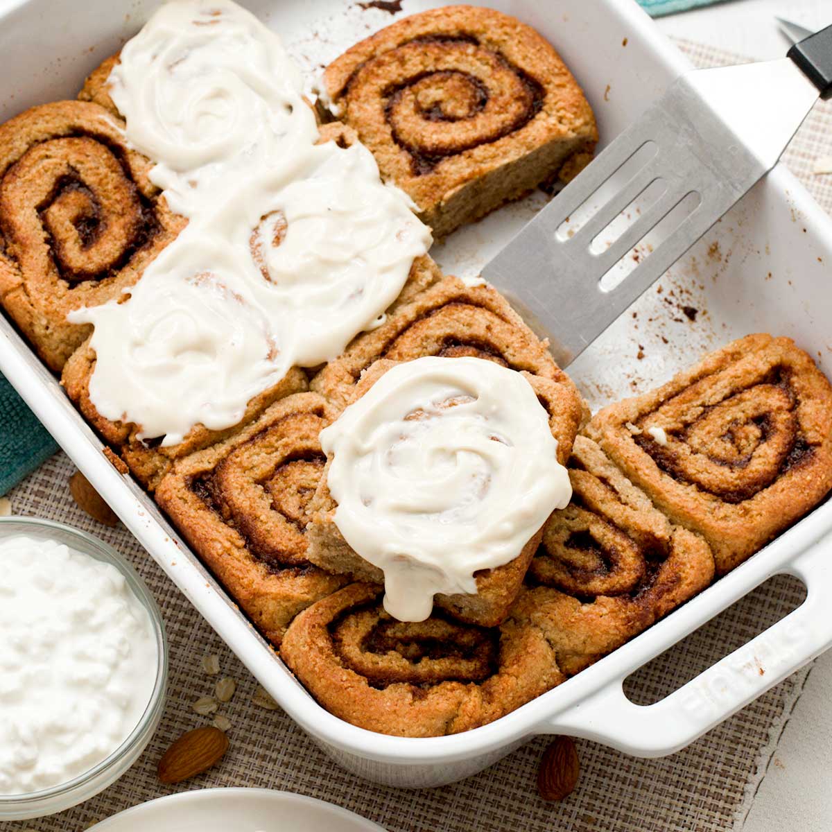 A baking dish with a batch of cottage cheese cinnamon rolls made gluten-free with oat and almond flour.