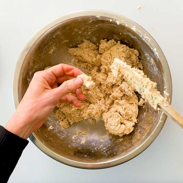 Mixing the cinnamon roll dough in a bowl with a spatula.