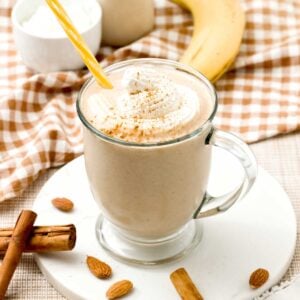 A cinnamon roll protein smoothie with greek yogurt and whipped cream on top.