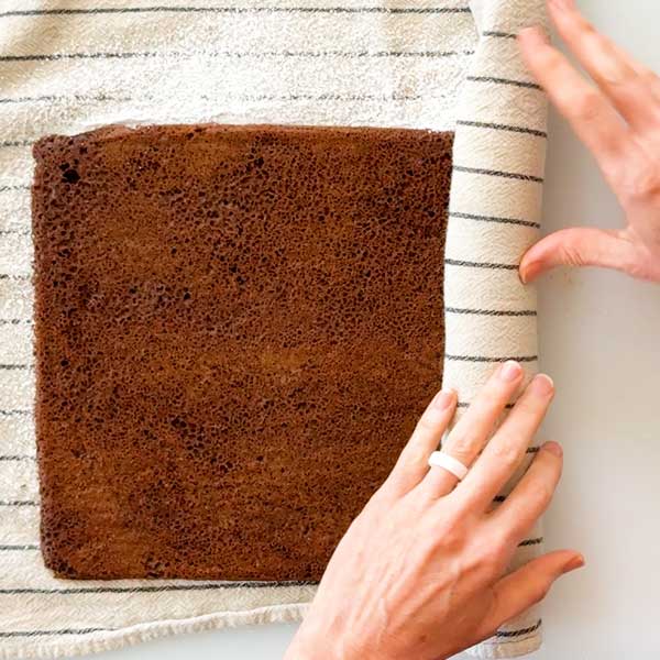 Rolling up the warm chocolate cake.