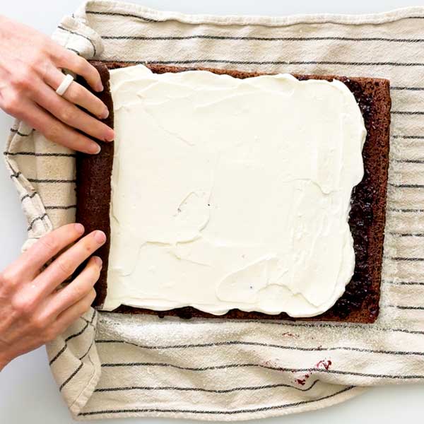 Rolling the cake back up with the cherry compote and cream layer inside.