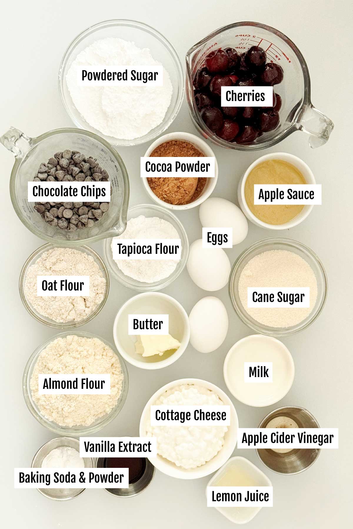 All the ingredients you need to make a gluten-free chocolate Swiss roll with cherries and whipped cream on top.