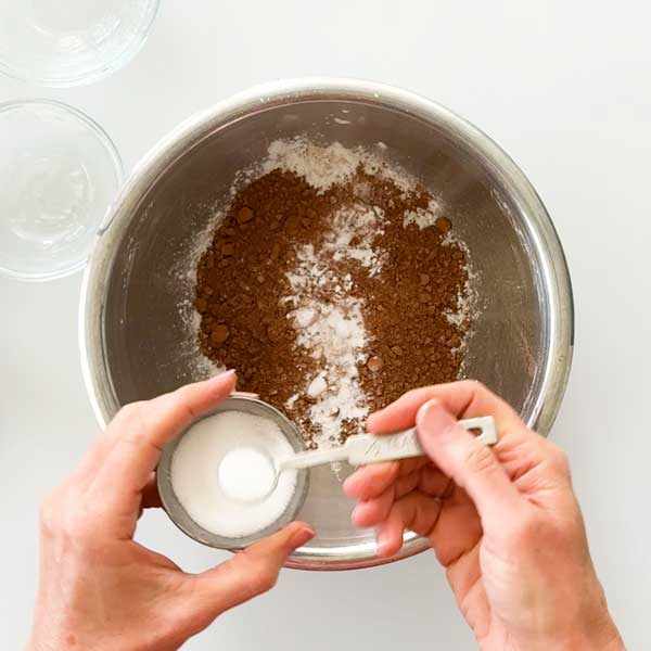 Adding the dry ingredients to a mixing bowl.
