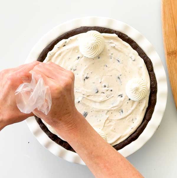 Piping 12 whipped cream dollops on top of the pie.