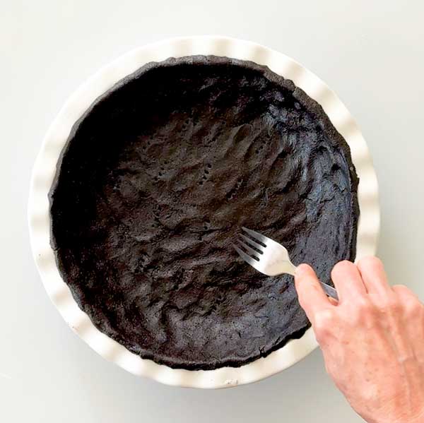 Poking air holes in the bottom of the pie crust.
