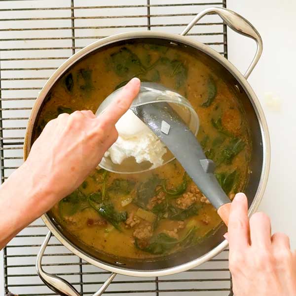 Adding the greek yogurt to the soup.