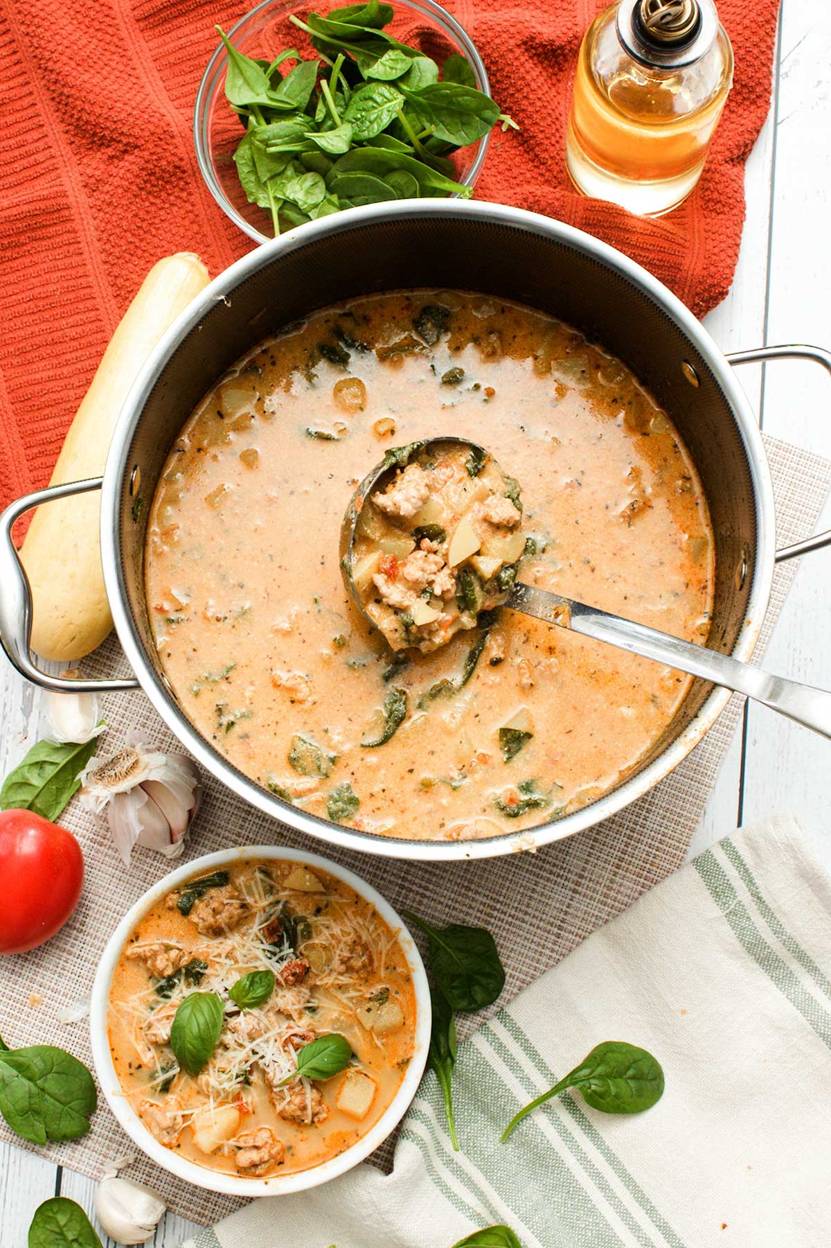 A pot and a bowl of healthy marry me chicken soup with greek yogurt with spinach and sun-dried tomatoes.