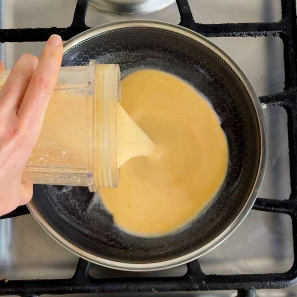 Pouring the egg batter in to the skillet over low heat.