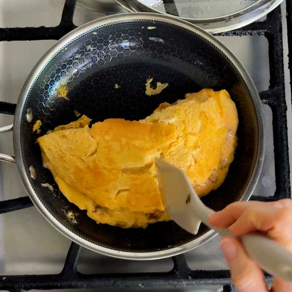 Folding the omelet in half in the skillet.
