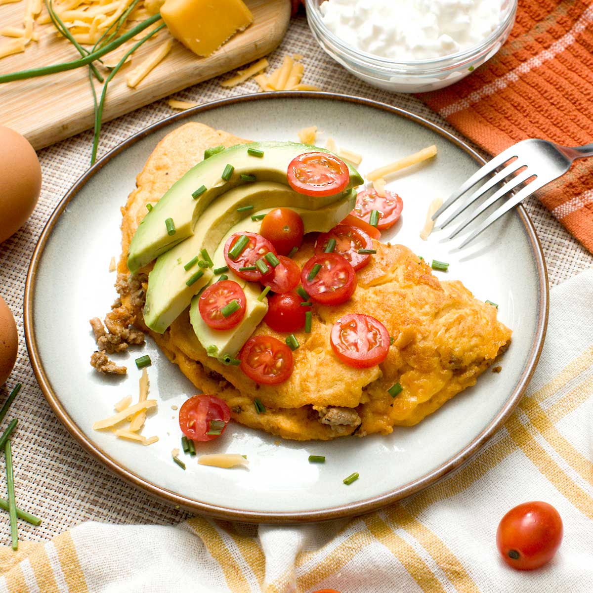 A high-protein cottage cheese omelet with tomatoes and avocado slices on top.