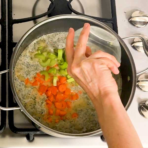 Adding the celery and carrots to the soup pot.