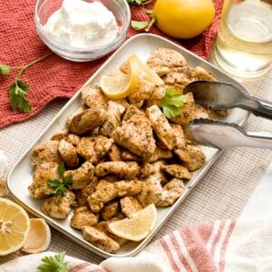 A dish with greek yogurt marinated chicken breast diced in bite-sized pieces.