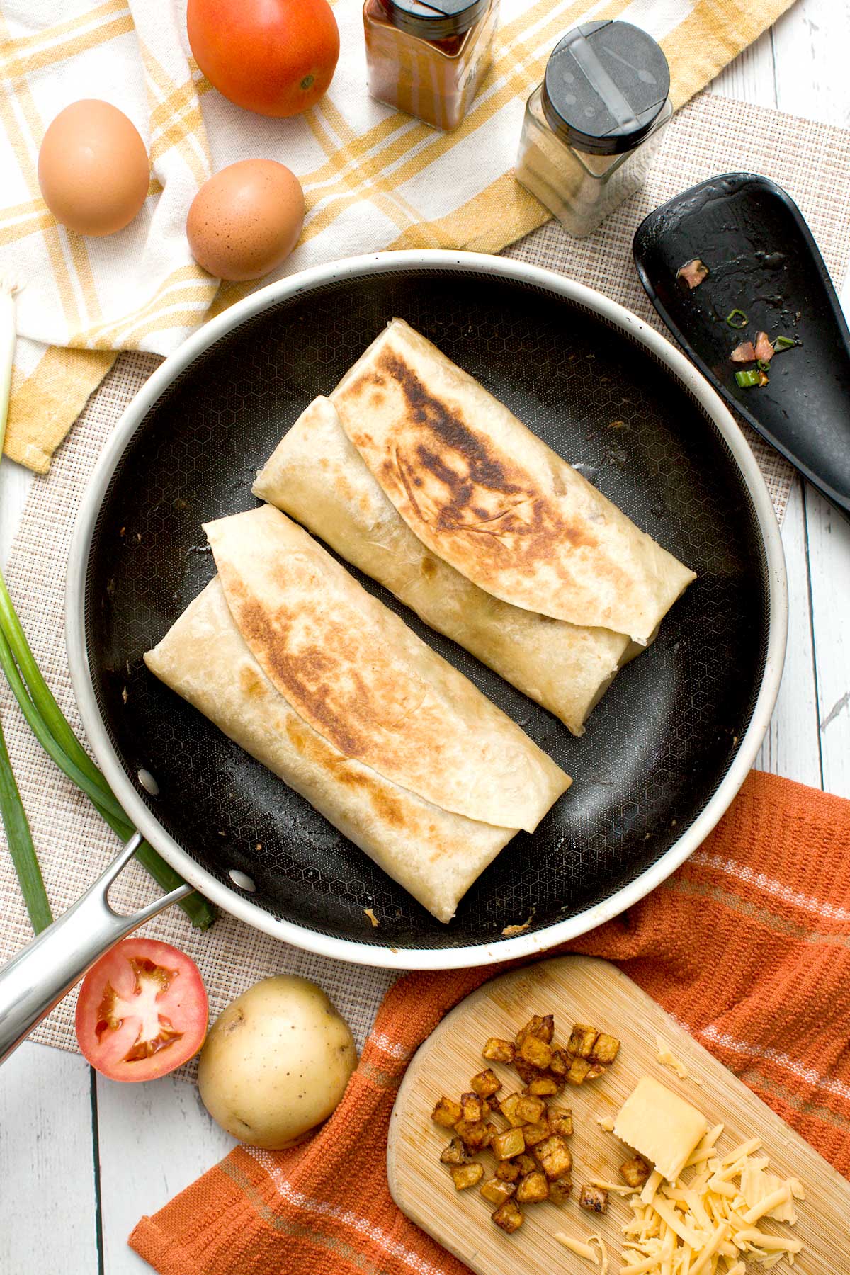 Two toasted high protein breakfast burritos in a skillet.