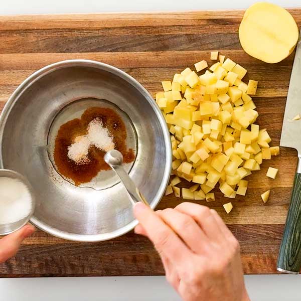 Mixing the seasonings in the light olive oil for the crispy potatoes.
