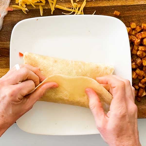 Folding the last tortilla flap over the burrito.